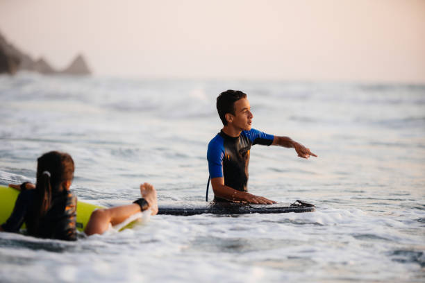 teenagers having an  active life surfing on the beach in the summer - surfing teenage girls friendship sunset photos et images de collection