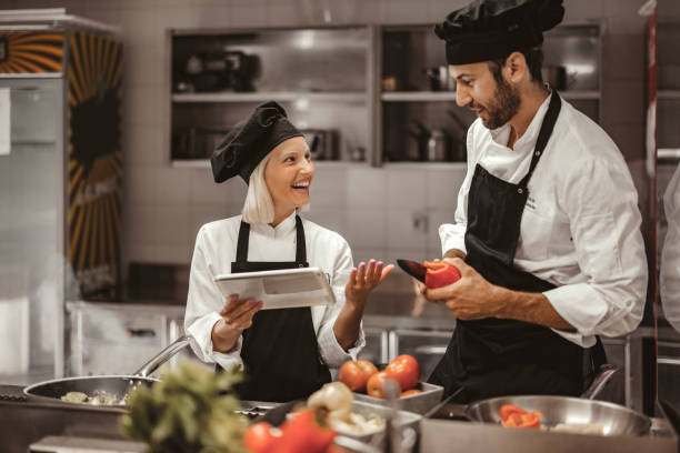 istock Male and Female Chefs Using Digital Tablet in a Modern Professional Kitchen 2038548353