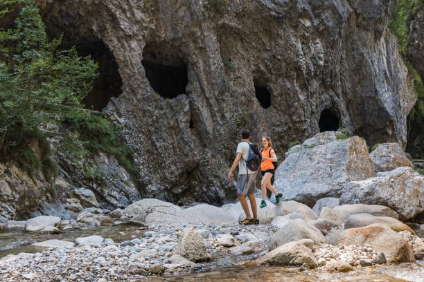 istock Hiker couple walking on the rocks while crossing mountain river 2038689749