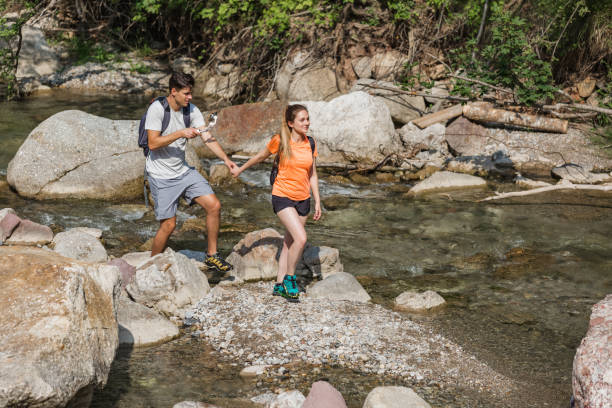 istock Young couple hiking along a mountain river shore 2038706577
