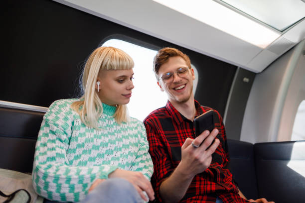istock Friends or a couple having fun with a smartphone in subway train 2038742621