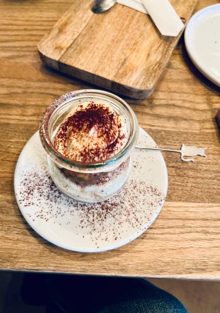 tiramisu dessert in a glass jar on a wooden table - biscotti cookie chocolate pistachio 뉴스 사진 이미지