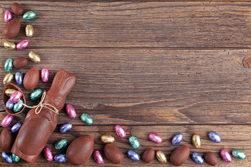 Chocolate Easter eggs and rabbit on rustic wooden background