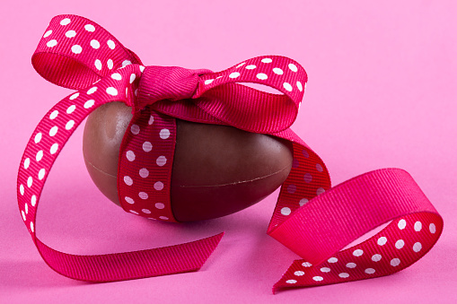 Chocolate Easter egg with pink ribbon bow