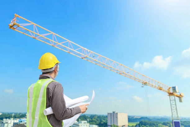 istock construction engineer worker in protective helmet and blueprints paper on hand at building site background 2038818495