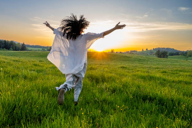 istock Woman with spread hands running in field 2038818501