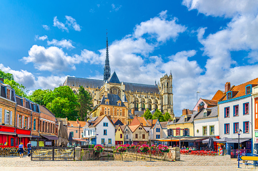 Amiens old town Saint-Leu quarter with colorful houses, restaurants and Amiens Cathedral Basilica of Our Lady Roman Catholic church in historical city centre, Hauts-de-France Region, Northern France