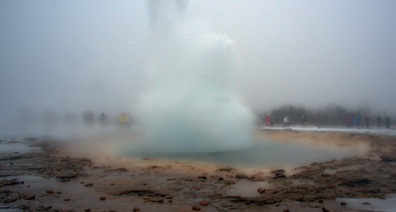 The Strokkur geyser erupting in Iceland's Geothermal Valley, an attraction along the Golden Circle Route.