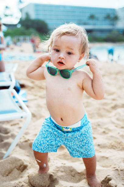 istock Curious toddler boy standing on the sandy beach 2038950947