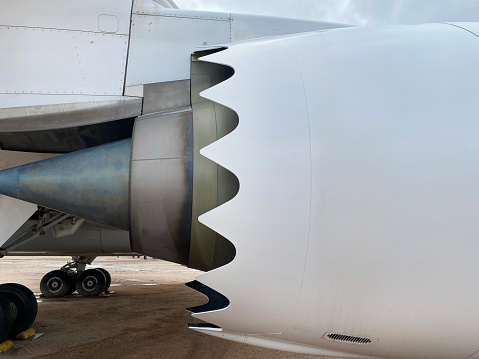 In this close-up view, we admire the intricately designed chevrons on the exhaust nozzle of a Boeing 787 GEnx engine, symbolizing the cutting-edge engineering behind modern aviation.\n\nBoeing's commitment to innovation is evident in the development of the GEnx engine, which features advanced technologies to improve performance and sustainability. The chevrons on the engine's exhaust nozzle play a crucial role in reducing noise emissions, making the Dreamliner quieter and more comfortable for passengers and communities around airports. As aviation continues to evolve, the chevron design remains a testament to Boeing's dedication to pushing the boundaries of efficiency and environmental responsibility.