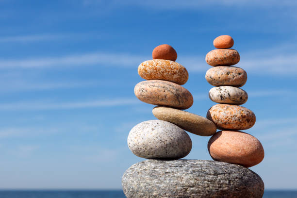 istock Two pyramids of colored balanced rocks on a background of blue sky. 2038964851
