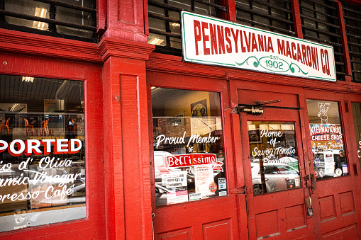 In Pittsburgh, PA, the iconic Pennsylvania Macaroni shop boasts its timeless charm with a vibrant red facade in the historic Strip District.