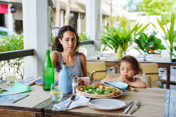 istock Mother eats lunch with toddler daughter outside at restaurant table 2038985771