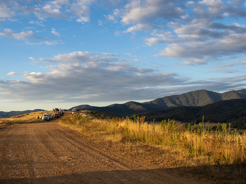 Golden light on dirt road and parked cars at look out spot in the Buckland Valley