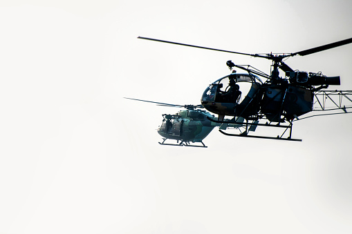 Two silhouette helicopter are flying on isolated background