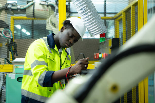 istock Portrait of a technician working with a digital multimeter to test the electrical system of a huge circuit board at an industrial plant using an automated hand robot. 2039394887