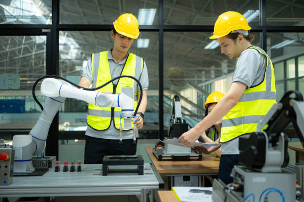 istock Group of engineers and technicians learning the technology to control hand robots for industrial usage. 2039434488
