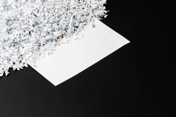 Shredded white paper on black background close up photo