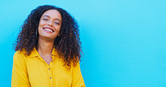 Happy, African woman and portrait on blue background, mockup or studio for natural beauty, cosmetics and confidence. Face, smile and model with healthy dermatology skincare or hair care on wall space