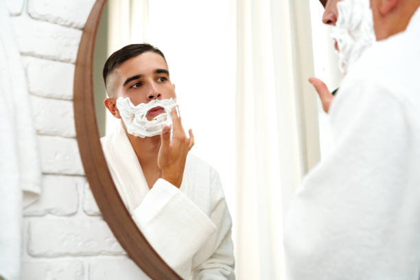 istock Reflection of a young man shaving in bathroom mirror close up 2039494563