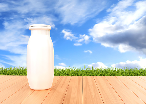 Bottle of yogurt on the table on background of grass and sky. Natural food concept. 3d-rendering