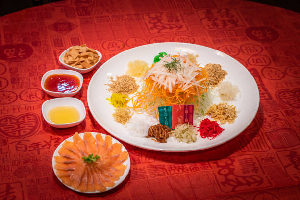 fresh colourful asian festive vegetables salad lo hei yu sheng with smoked salmon, fish skin, cookies and sweet spicy sauce buffet corner for chinese new year halal food menu for banquet restaurant