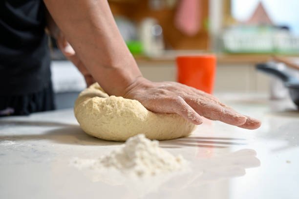 Adult woman kneading dough on the table