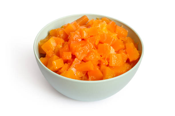 Butternut squash cross cut and standing in bowl on a rustic table with juice drops coming out on the cut, top view close-up in selective focus