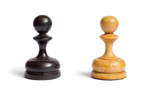 Black and white chess pawns on a white background. Old wooden chess pawns.
