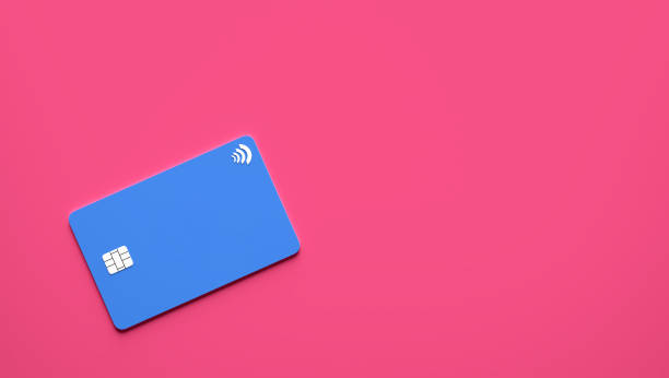 Blue plastic credit card on pink background with copy space.