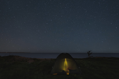 Camping with a tent on the shore of the steep Baltic Sea in Paldiski under the starry sky. High quality photo