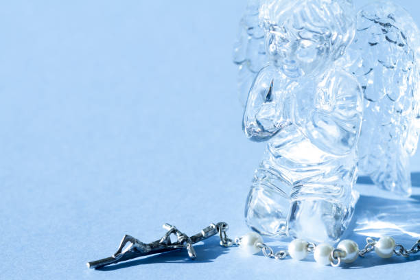Crystal angel figurine and rosary, abstract creative religion concept background