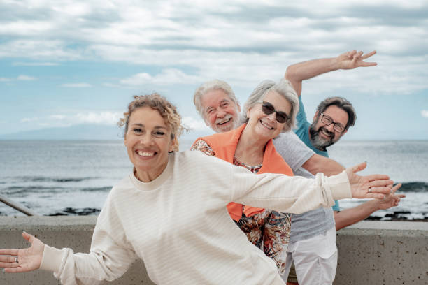 istock Happy playful multigenerational family group outdoors at seaside expressing joy by gesturing with hands towards camera 2039671598