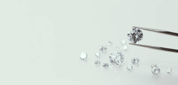 istock brilliant cut diamond held by tweezers 2039684969