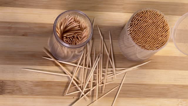 Wood toothpicks in plastic containers and scattered beside