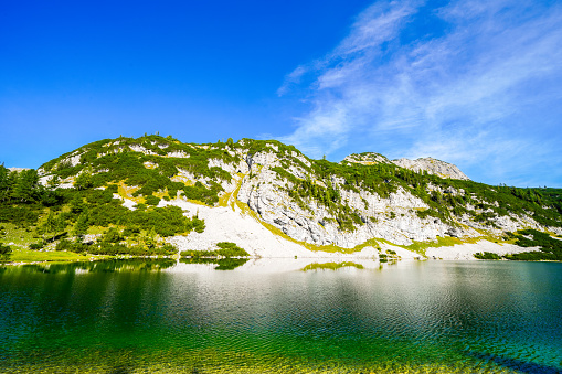 Schwarzensee on the high plateau of the Tauplitzalm. View of the lake at the Totes Gebirge in Styria. Idyllic landscape with mountains and a lake on the Tauplitz in Austria.