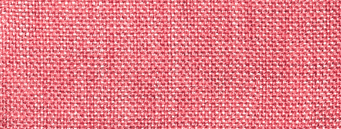 Texture of light red color background from woven textile material with wicker pattern, macro. Structure of vintage pink fabric cloth, narrow backdrop.