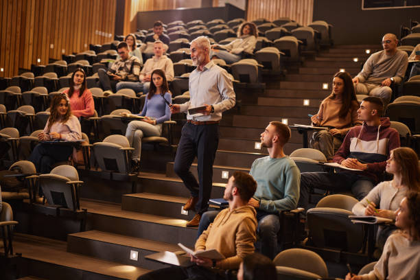 istock Happy senior professor teaching his students in lecture hall. 2039719009