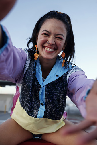 Close Up Smiling South American Woman Wearing Colorful Jacket in the Rooftop in a Late Afternoon