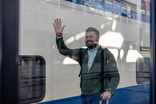 Captured in the act of leaving the train, a Caucasian man is seen navigating the train station, heading towards the exit to continue his journey