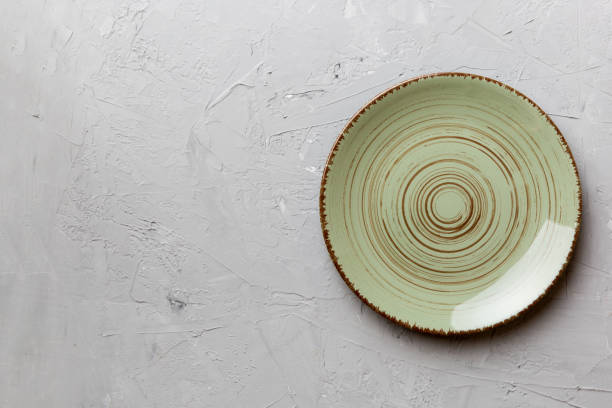istock Top view of empty green plate on cement background. Empty space for your design 2039751732
