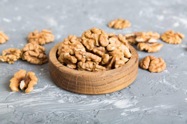 fresh healthy walnuts in bowl on colored table background. top view healthy eating bertholletia concept. super foods - close up table brown dieting - fotografias e filmes do acervo