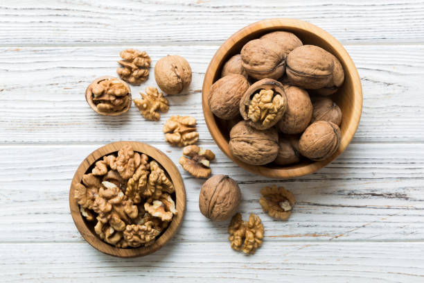 istock Fresh healthy walnuts in bowl on colored table background. Top view Healthy eating bertholletia concept. Super foods 2039752284