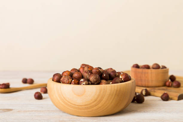 wooden bowl full of hazelnuts on table background. healthy eating concept. super foods - close up table brown dieting - fotografias e filmes do acervo