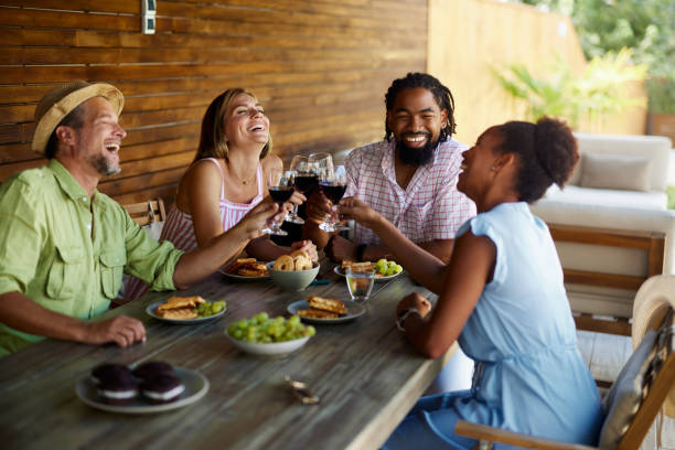 istock Happy diverse couples toasting with wine at dining table on a patio. 2039756058