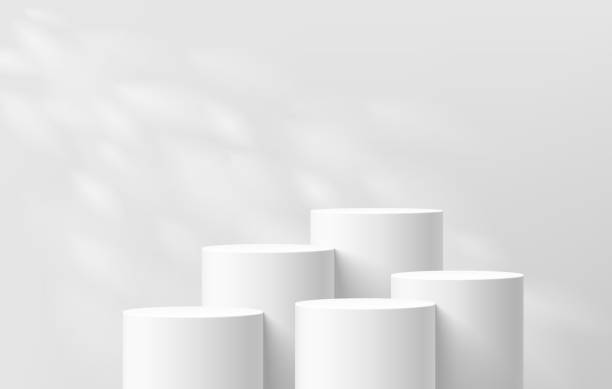 istock 3D background with set of realistic white cylinder podium pedestal and natural leaf light scene. Abstract composition in minimal design. Platforms mockup product display presentation. Stage showcase. 2039761023