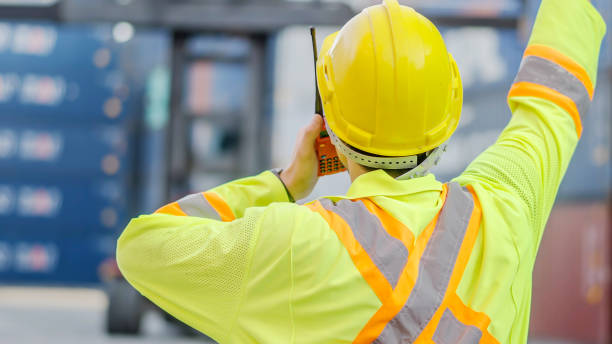 istock Dock foreman with a radio standing against the background of cargo containers 2039772482