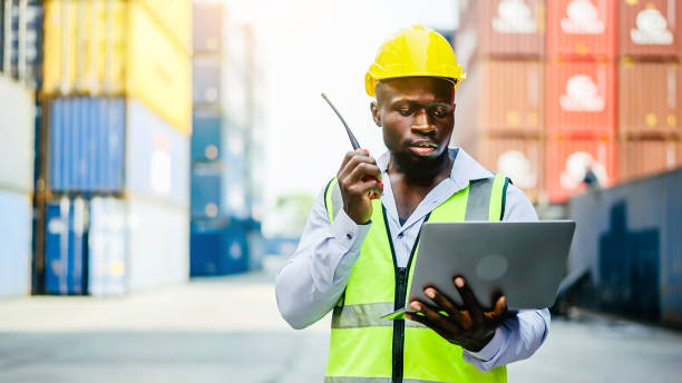 istock Dock foreman with a laptop and radio standing in front of cargo containers 2039773555