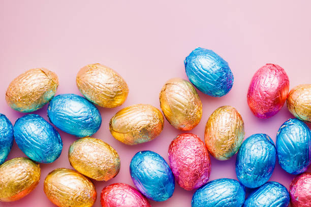 istock Easter chocolate eggs wrapped in aluminium foil on pink background. 2039781241