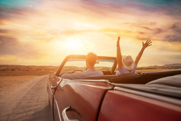 happy people traveling in classic vintage car, couple on honeymoon - kabrio stok fotoğraflar ve resimler